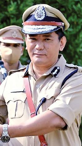Wabang Jamir, IPS, in peaked cap and service uniform standing at attention during an official ceremony.