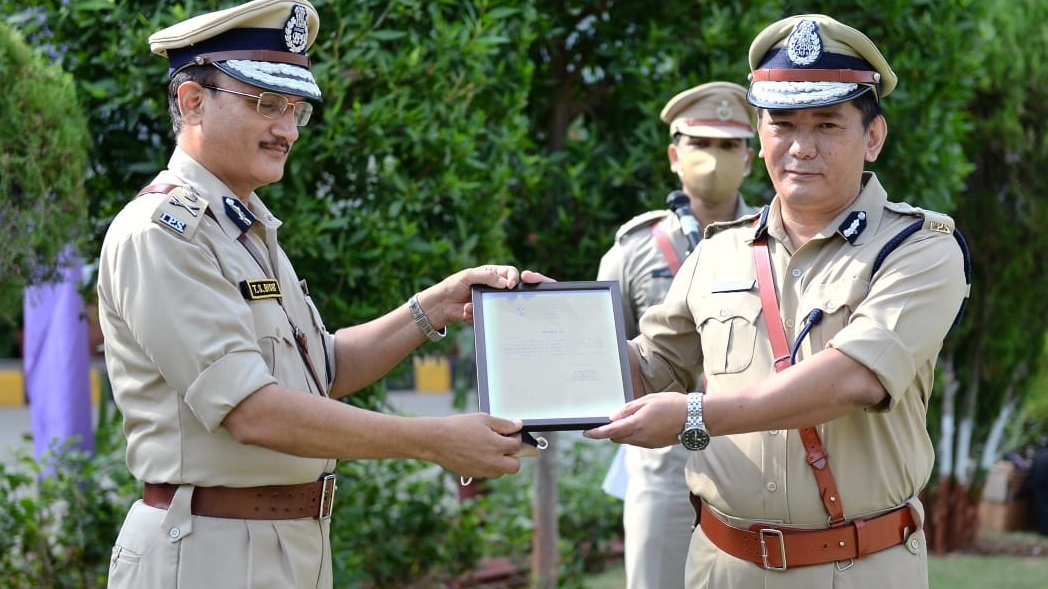 Wabang Jamir, IPS, receiving a framed citation from a senior Gujarat Police officer at an award ceremony.